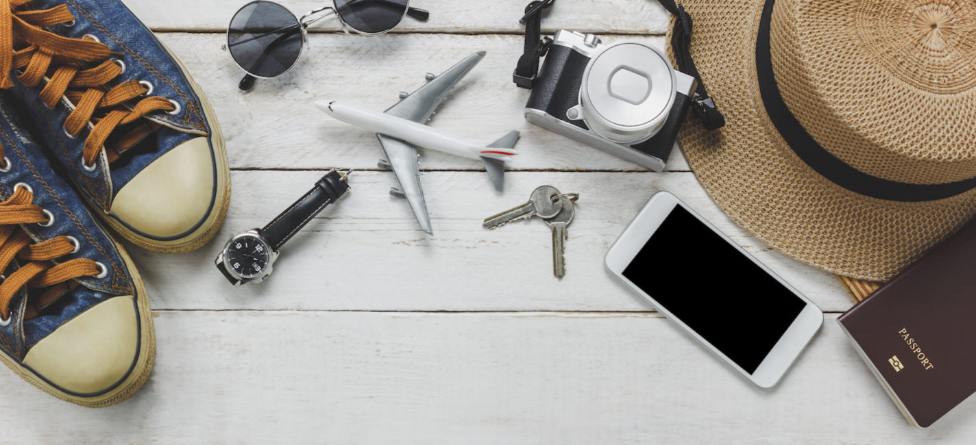 Top View Women Accessoires To Travel Concept White Mobile Phone Airplane Hat Passport Watch Sunglasses On Wood Table